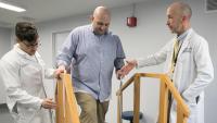 Clinic staff assisting patient on stairs
